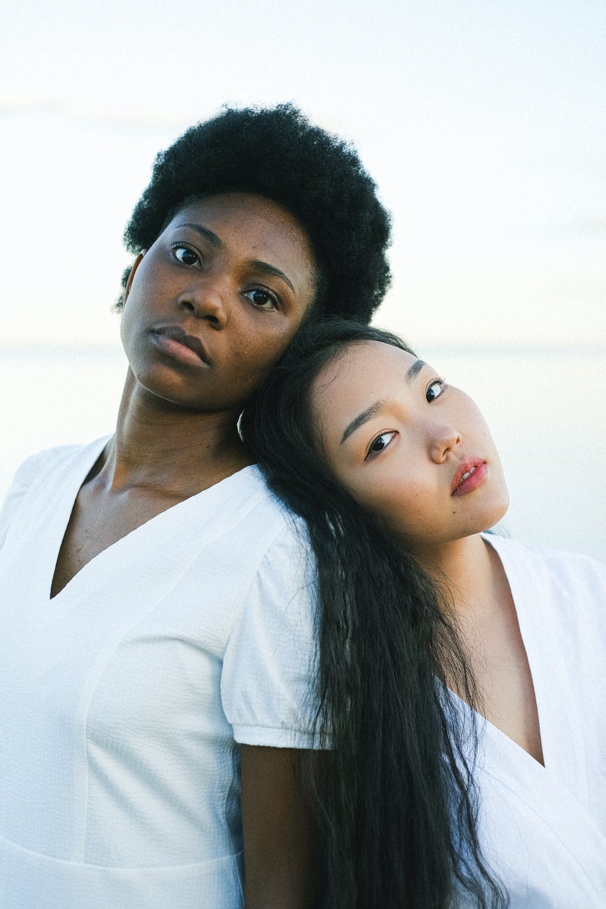 two women leaning on each other s back