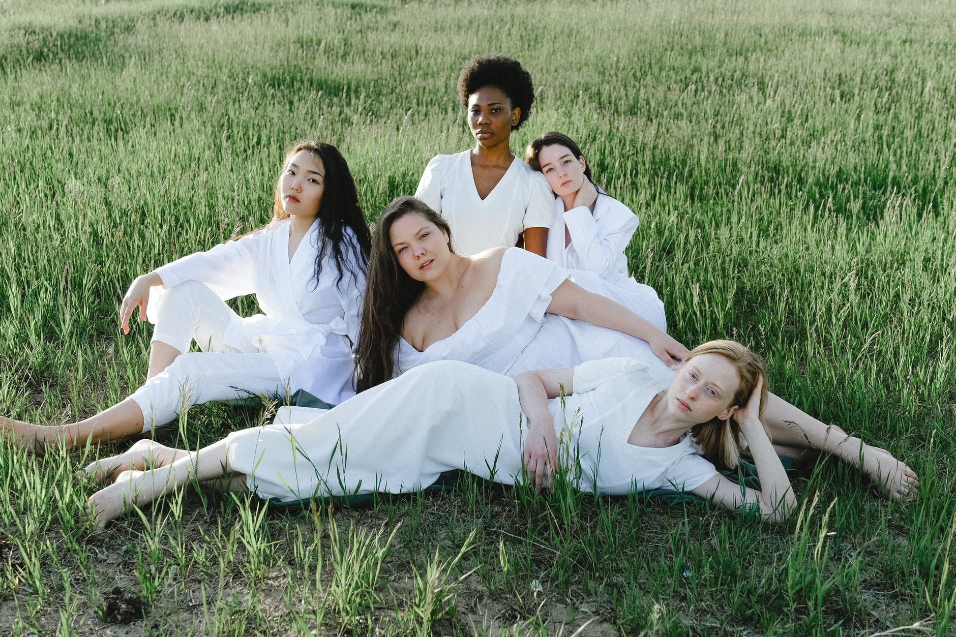 group of women lying on green grass field